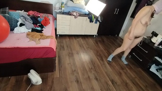Une femme homemade s'amuse à essayer des vêtements et à les couper. Une femme amatuer danse nue dans